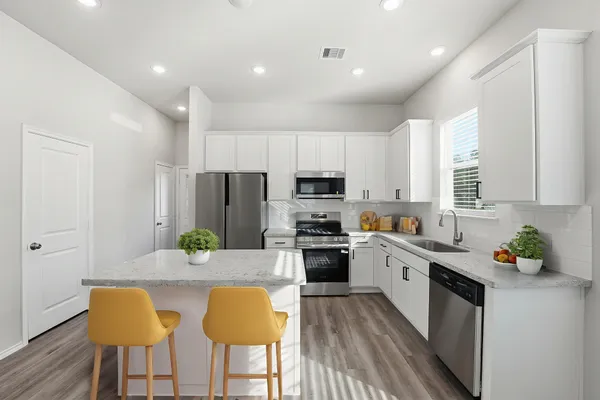 a kitchen with white cabinets and stainless steel appliances