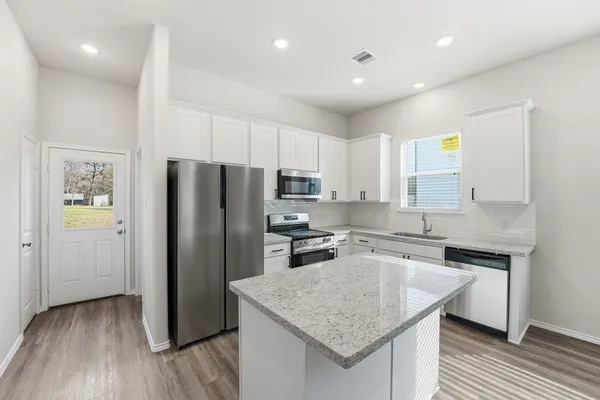 a kitchen with a refrigerator a sink and wooden cabinets