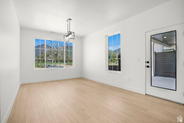 1631 West Century Lane, Unit C Mapleton, UT 84664 - Photo 9 of 31 Spacious room featuring light wood-finish flooring, white walls, and a contemporary linear chandelier
