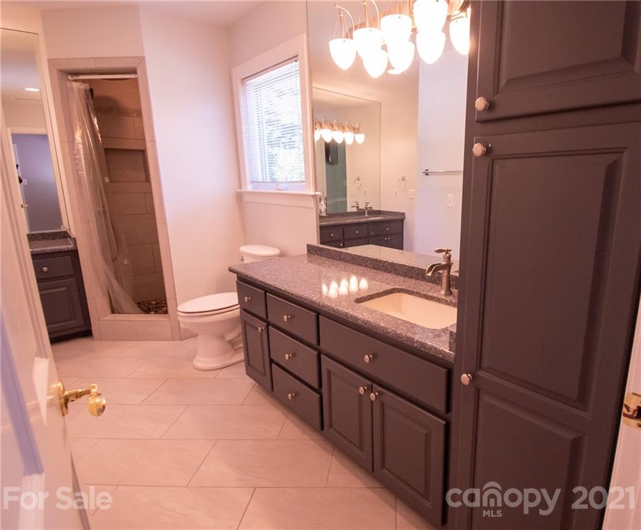 127 Alan Drive Boone, NC 28607 - Photo 28 of 37 a bathroom with a granite countertop sink a mirror and a shower