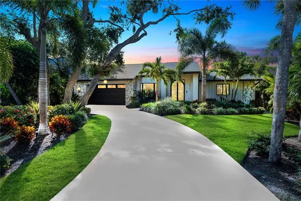 a front view of a house with a yard and potted plants