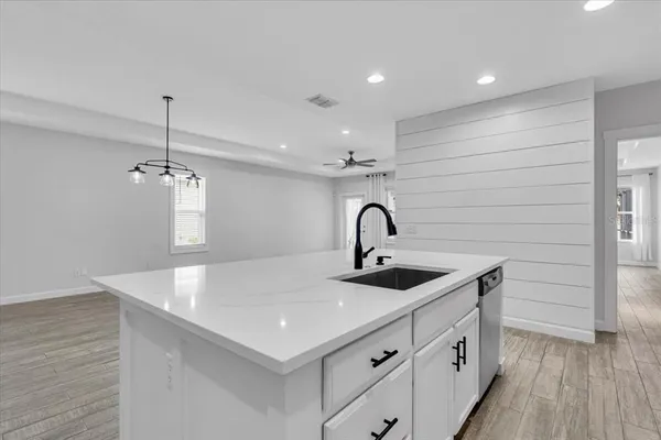 a kitchen with stainless steel appliances a sink a stove a refrigerator and cabinets
