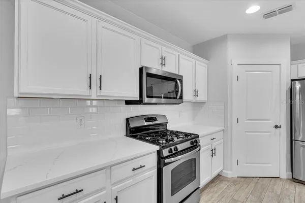a kitchen with kitchen island a sink stainless steel appliances and cabinets