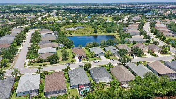 an aerial view of residential houses with outdoor space and lake view