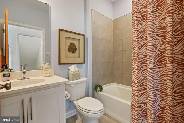 a bathroom with a toilet a sink a mirror a bathtub and shower