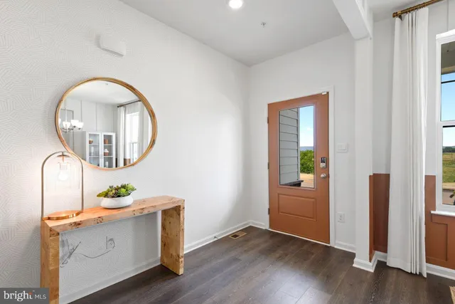 an entryway with wooden floor and mirror