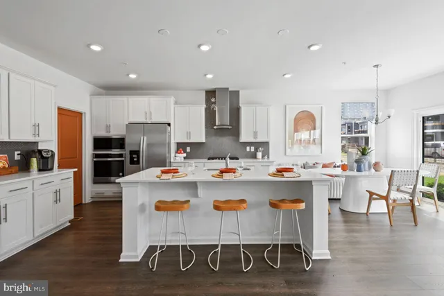 a kitchen with a dining table chairs refrigerator and cabinets