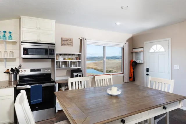 a kitchen with stainless steel appliances wooden floor dining table and chairs