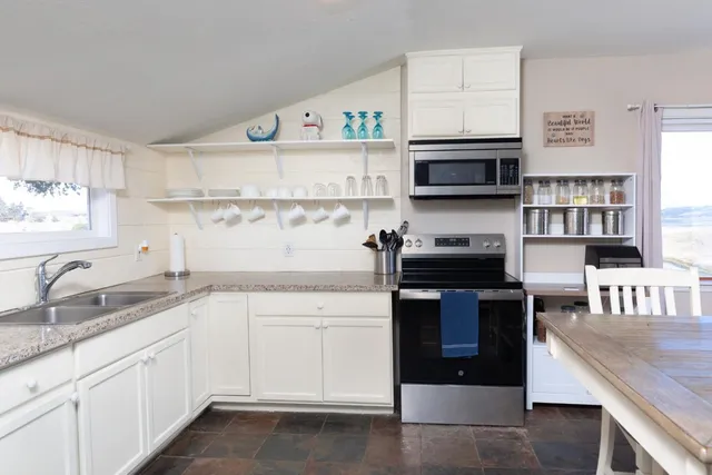 a kitchen with stainless steel appliances granite countertop a sink and stove top oven