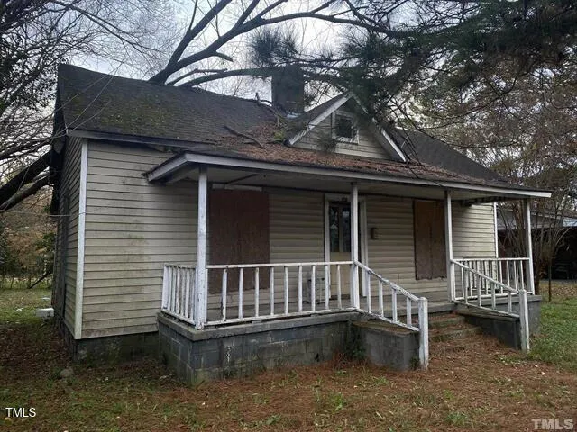 a view of house with a small yard and wooden fence