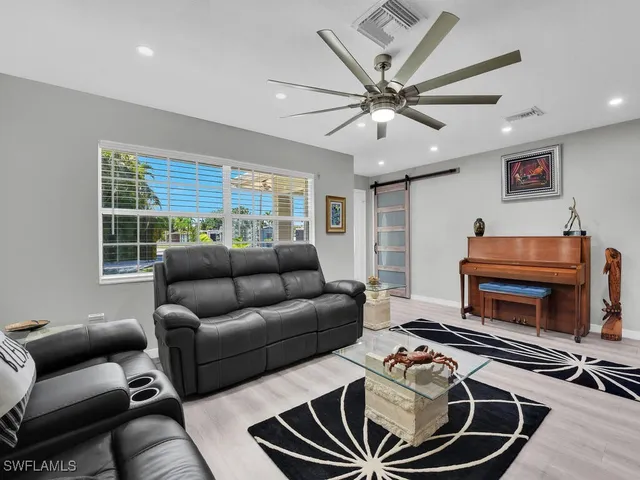 a living room with furniture a flat screen tv and a window