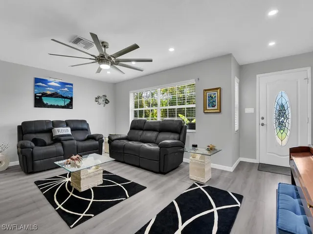 a living room with furniture a desk and chair with wooden floor