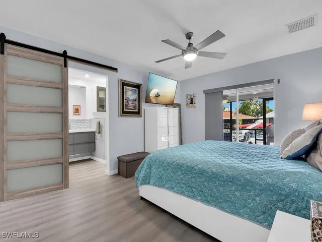 a bedroom with a large bed and a chandelier