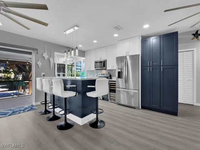 a kitchen with refrigerator and chairs