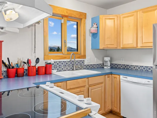 a kitchen with stainless steel appliances wooden cabinets and a large window