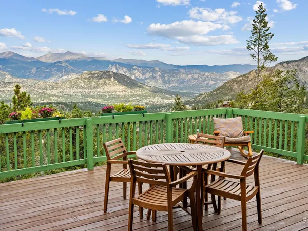 a view of a chairs and table on the wooden deck