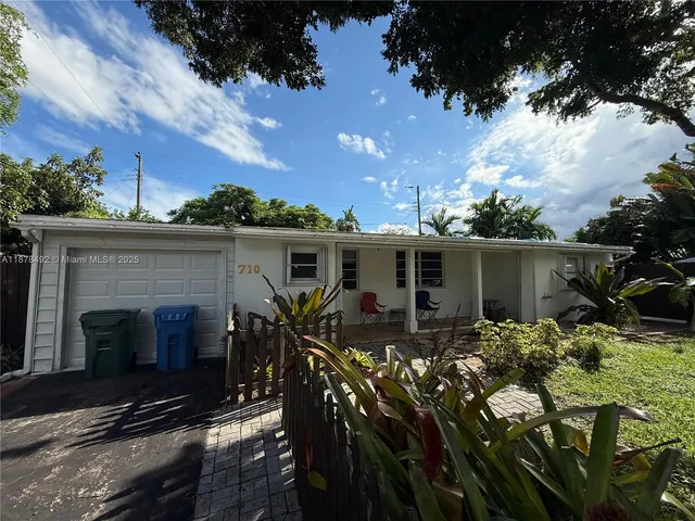 a view of a patio with table and chairs with wooden fence and plants