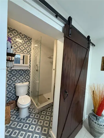 a bathroom with a toilet and a shower