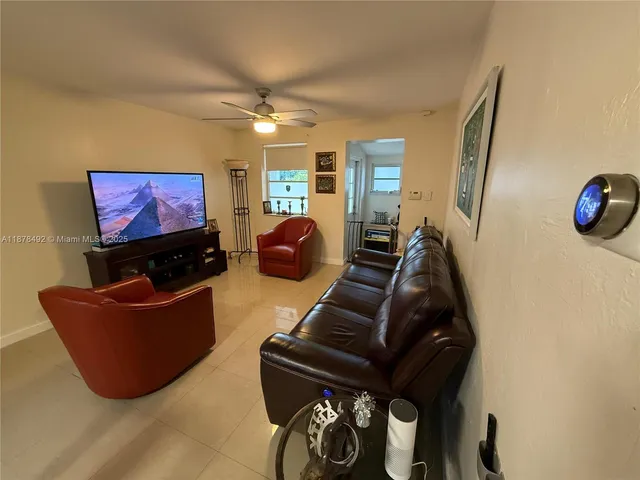 a living room with furniture a flat screen tv and a window