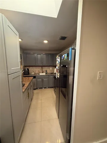 a kitchen with stainless steel appliances a refrigerator and a refrigerator