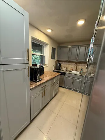 a kitchen with a sink a window and stainless steel appliances