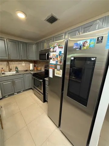 a kitchen with a sink stainless steel appliances a counter top space and cabinets