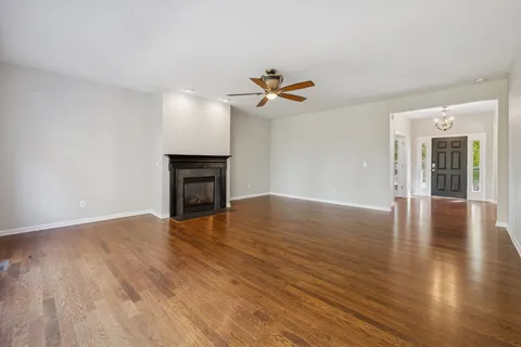a view of a livingroom with furniture a ceiling fan and wooden floor