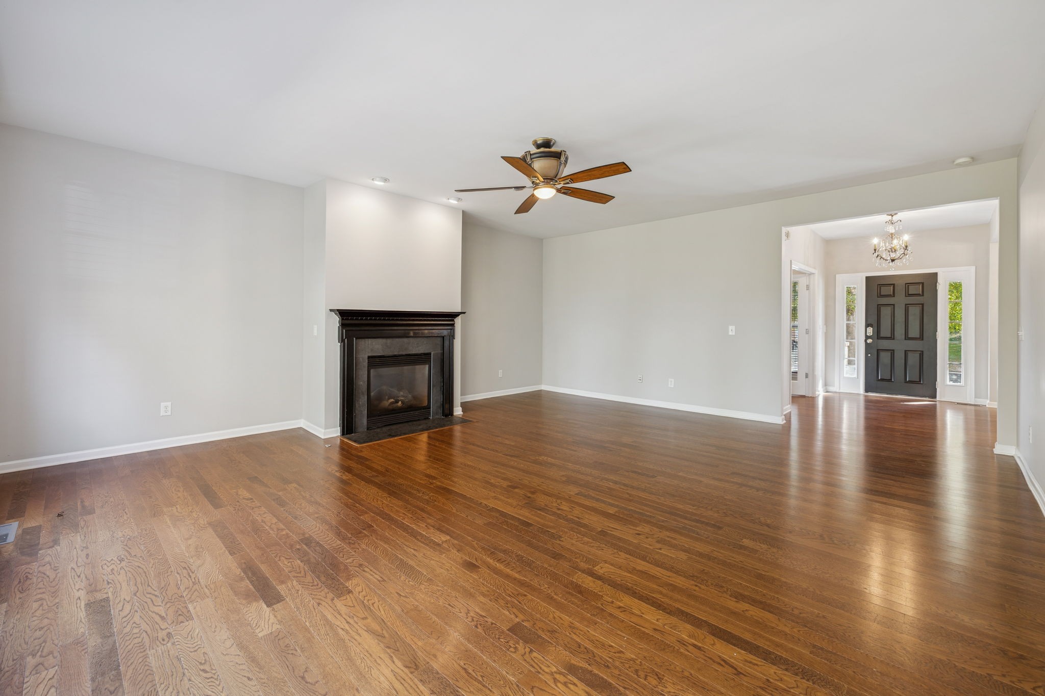 322 Forest Bend Drive Mount Juliet, TN 37122 - Photo 12 of 62 an empty room with wooden floor chandelier fan and windows
