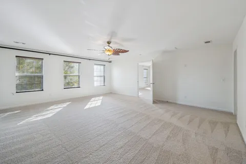 a view of a room with a chandelier fan and a bathroom