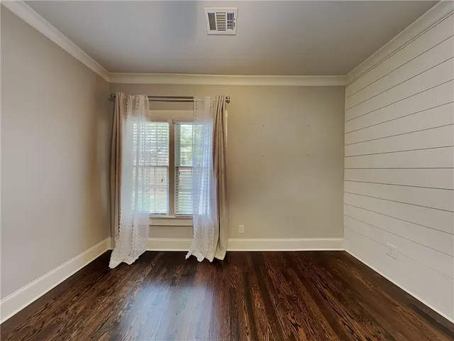 an empty room with wooden floor and door