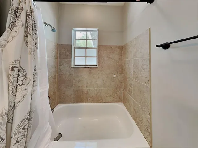 a bathroom with a bathtub and shower