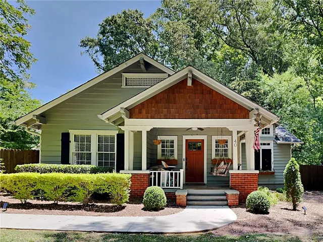 a front view of a house with a yard and potted plants