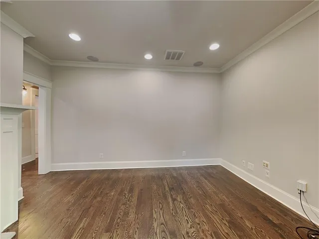 an empty room with wooden floor and white walls