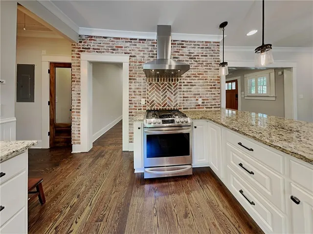a kitchen with granite countertop a stove and a wooden floors