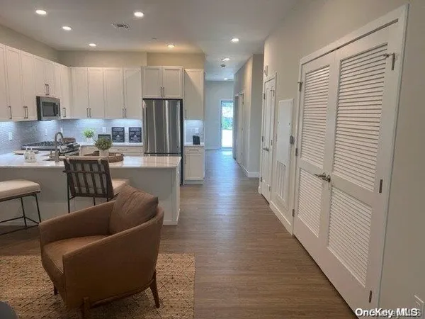 a living room with furniture a refrigerator and kitchen view