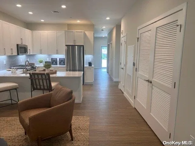 a living room with furniture a refrigerator and kitchen view