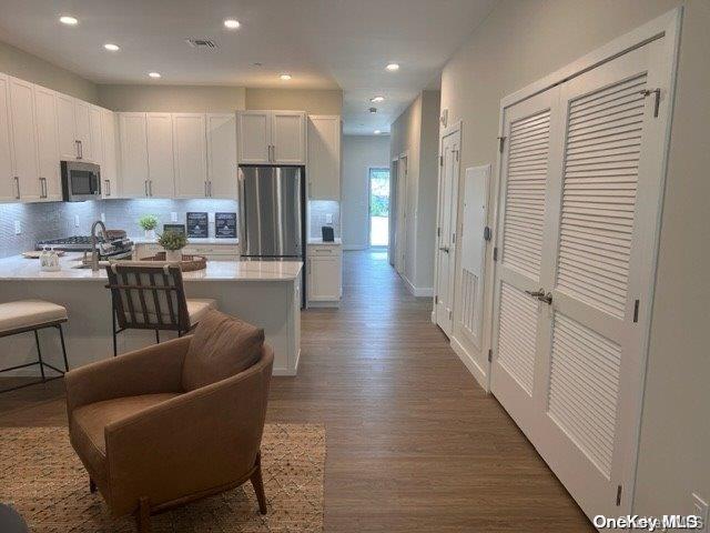 201 Jerusalem Hollow Road Manorville, NY 11949 - Photo 2 of 15 a living room with furniture a refrigerator and kitchen view