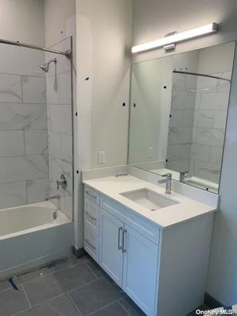 a bathroom with a bathtub double vanity sink and mirror