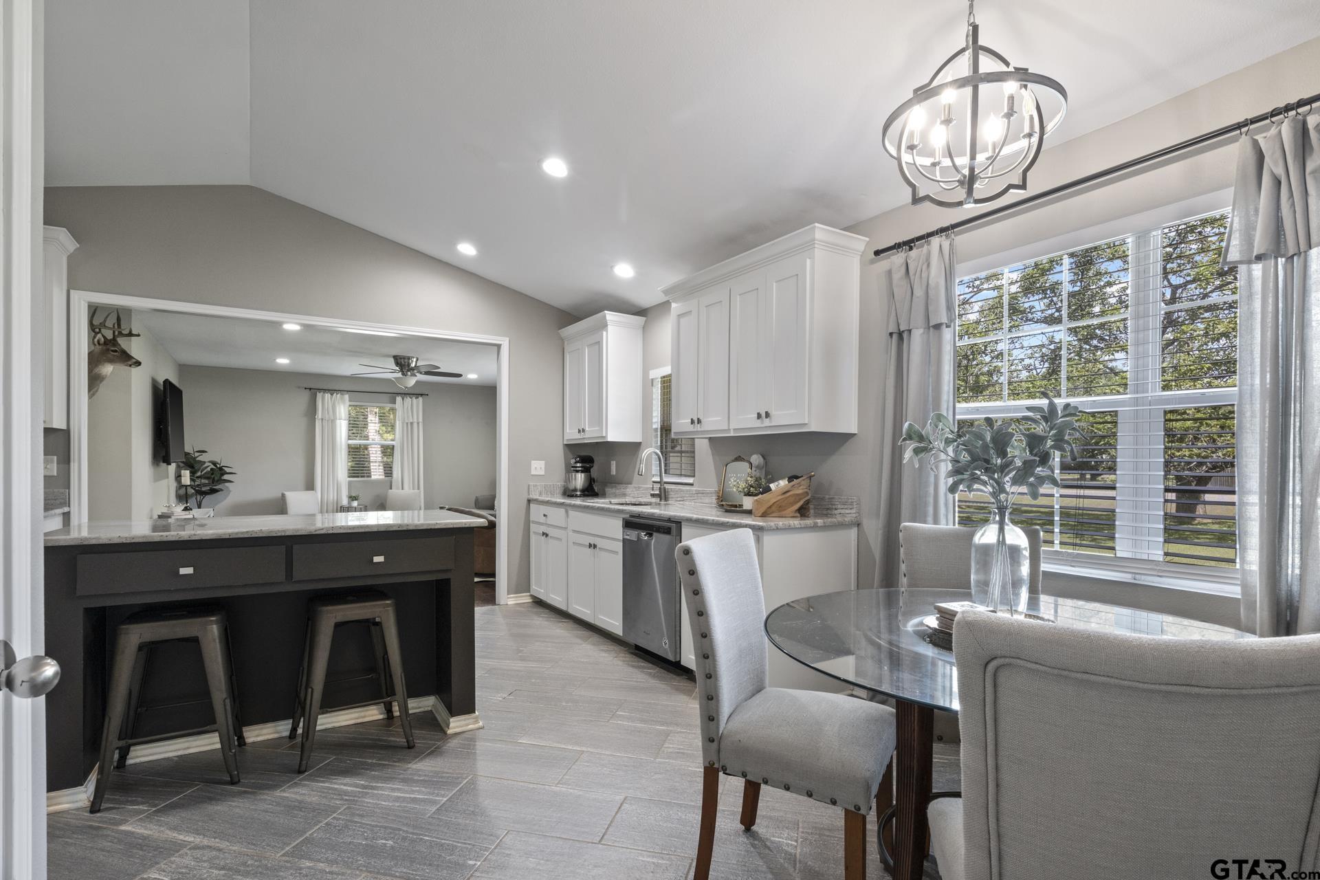 655 Daingerfield Street Pittsburg, TX 75686 - Photo 12 of 27 a kitchen with kitchen island granite countertop a table chairs sink and cabinets