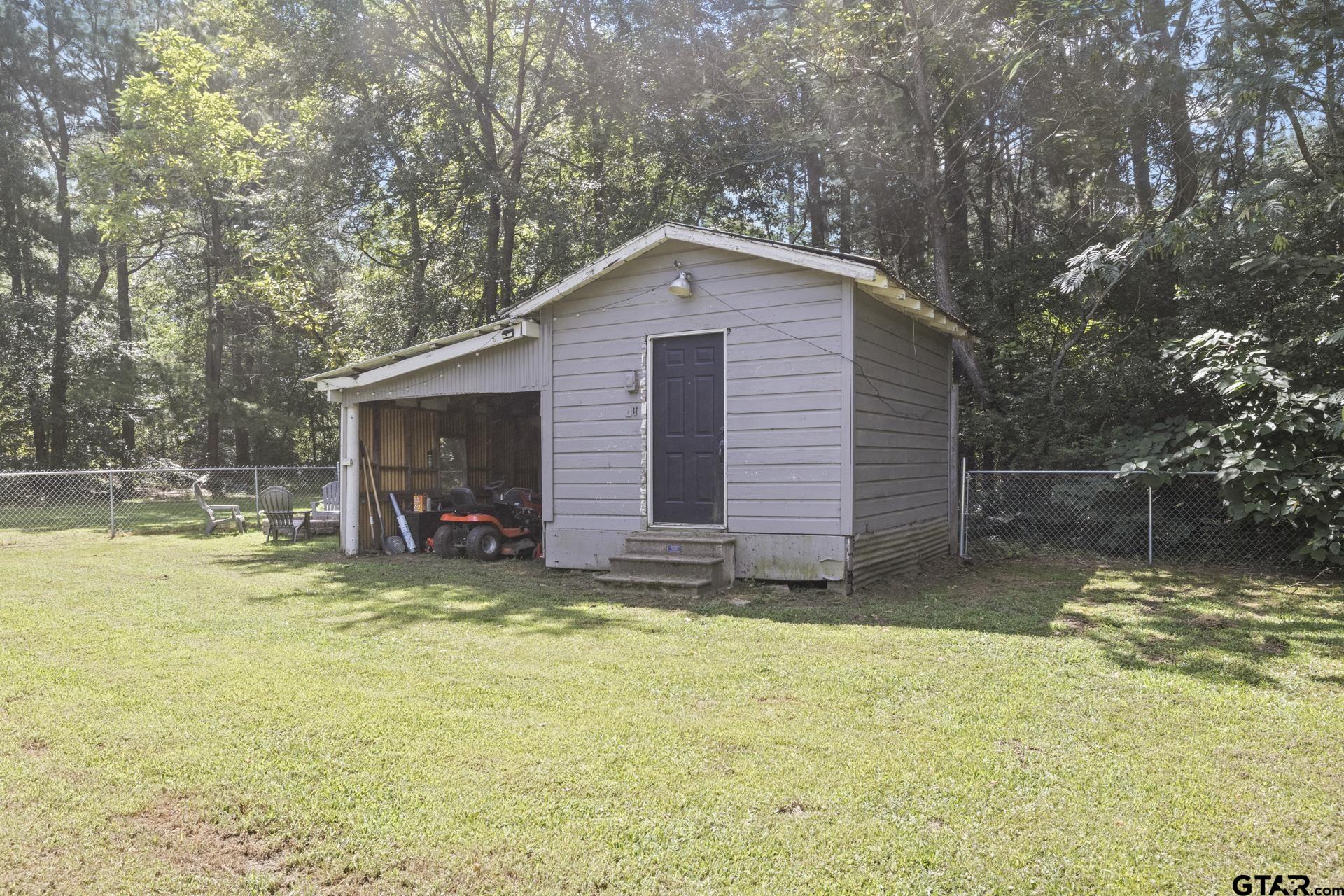 655 Daingerfield Street Pittsburg, TX 75686 - Photo 18 of 27 a view of a backyard with a small cabin