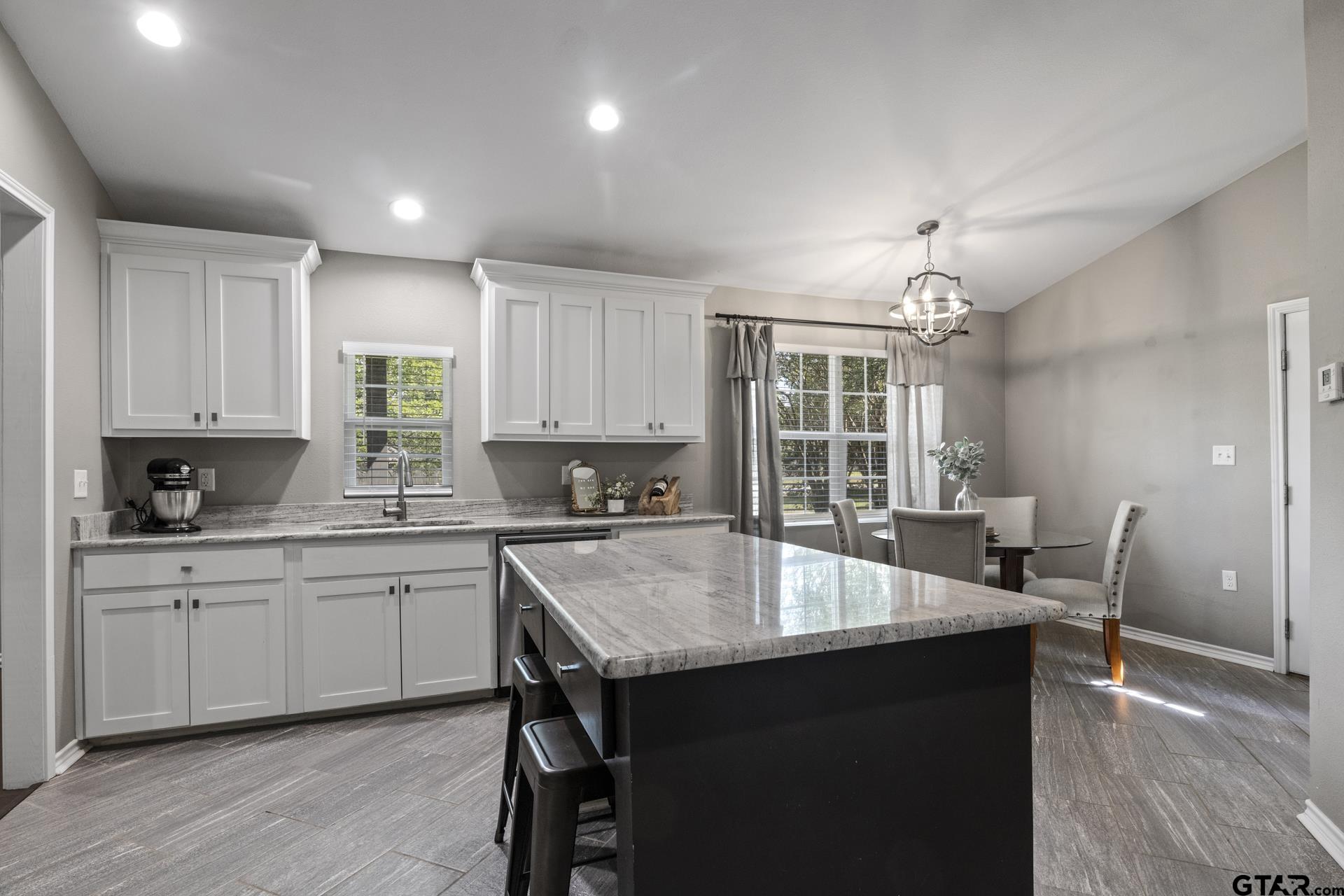 655 Daingerfield Street Pittsburg, TX 75686 - Photo 7 of 27 a kitchen with a table chairs sink and cabinets