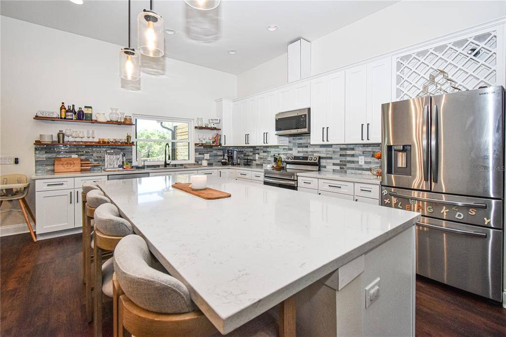 7890 Southwest 129th Avenue Cedar Key, FL 32625 - Photo 10 of 45 a kitchen with kitchen island a white counter top space stainless steel appliances and wooden floor