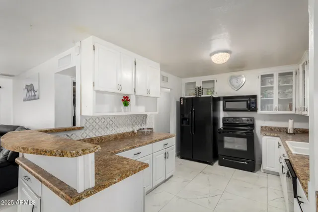 a kitchen with stainless steel appliances granite countertop a refrigerator oven a stove and a sink