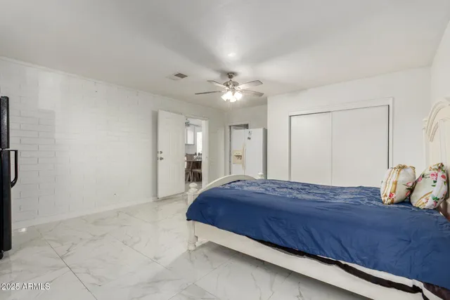 a bedroom with a bed and a ceiling fan