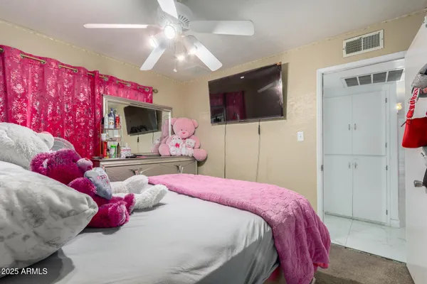 a bedroom with a bed and a flat screen tv