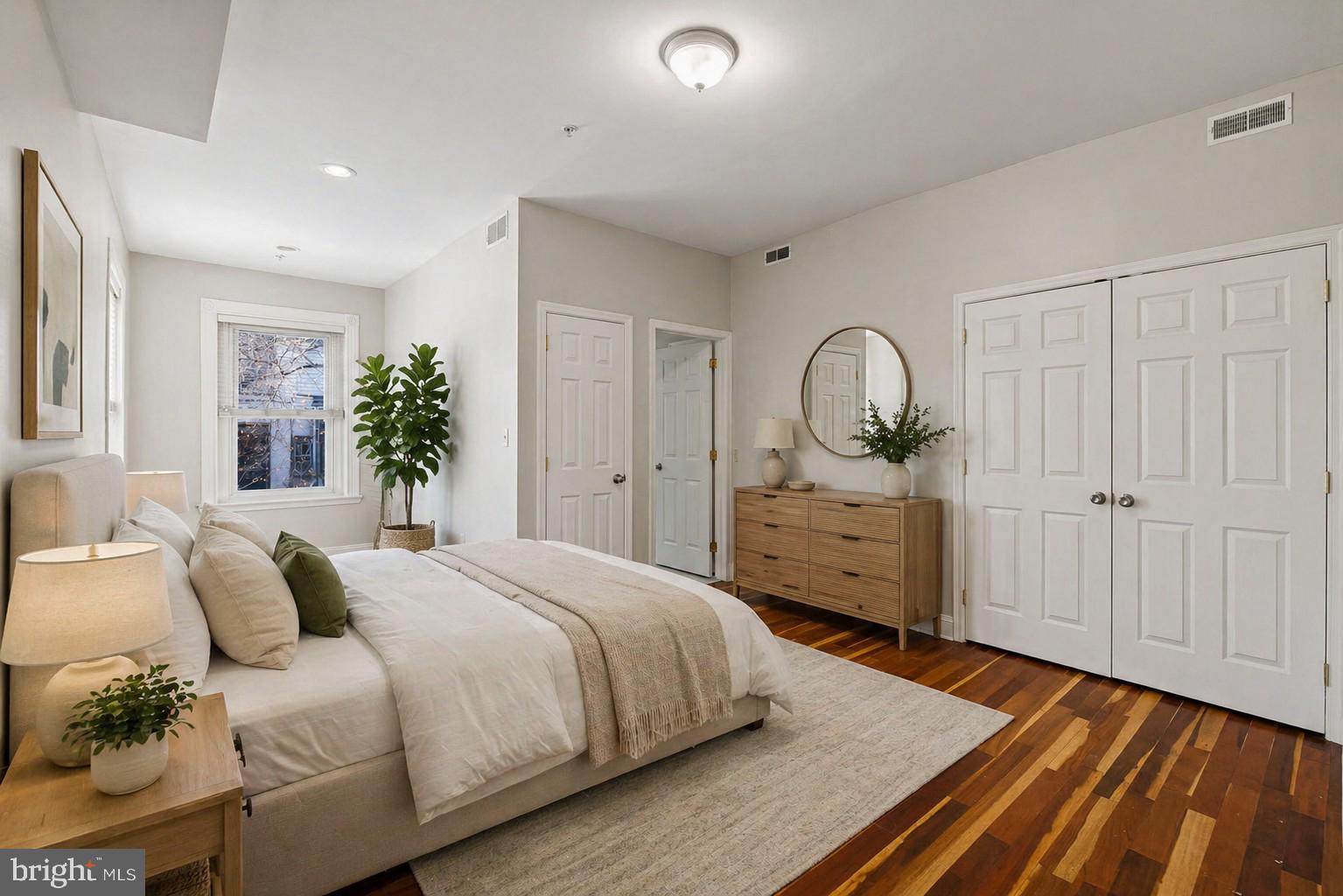 426 South 44th Street, Unit 2 Philadelphia, PA 19104 - Photo 16 of 29 a spacious bedroom with a bed a dresser and potted plants with the wooden floor