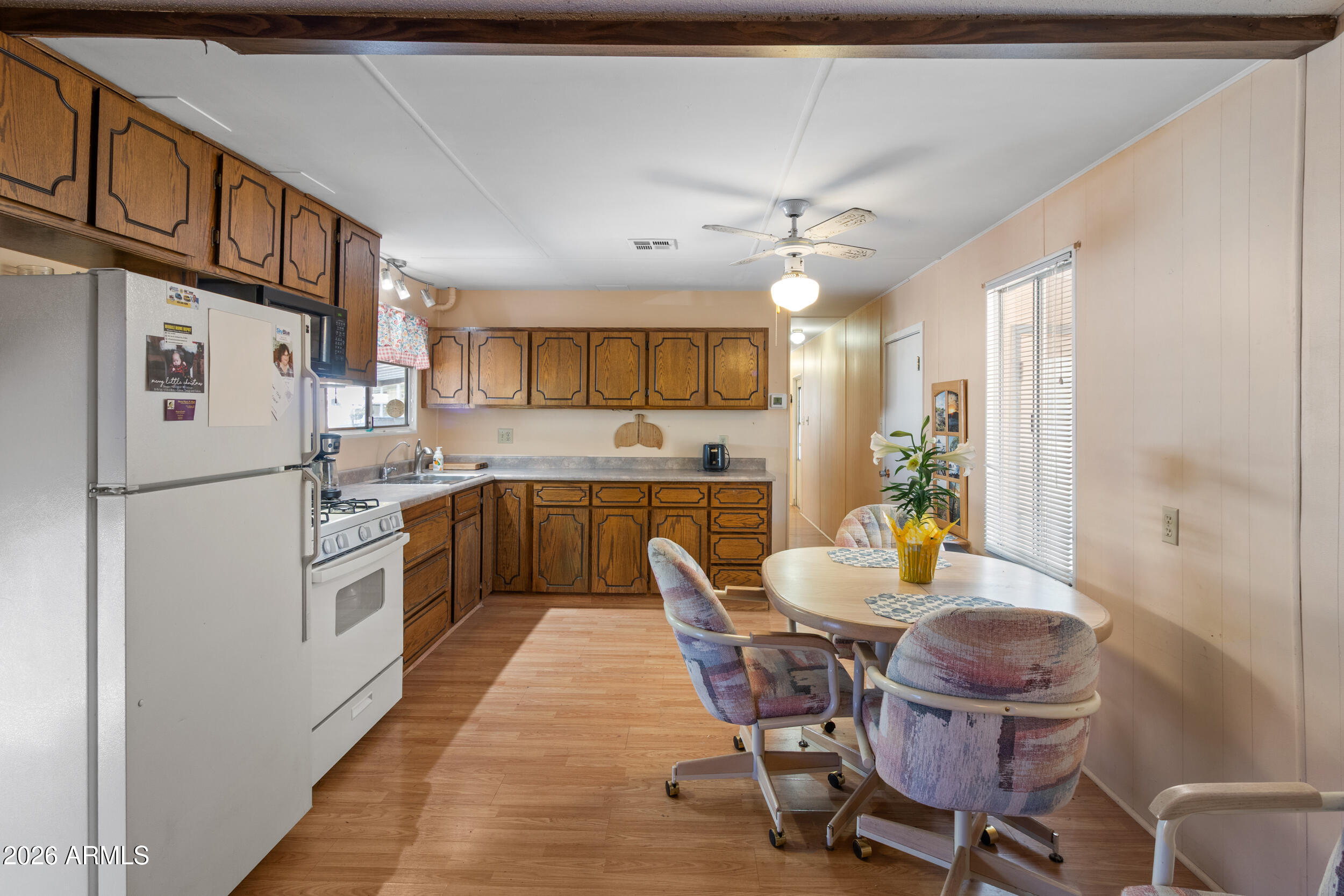 701 South Dobson Road, Unit 343 Mesa, AZ 85202 - Photo 12 of 70 a kitchen with stainless steel appliances a refrigerator a stove a sink dishwasher and white cabinets with wooden floor