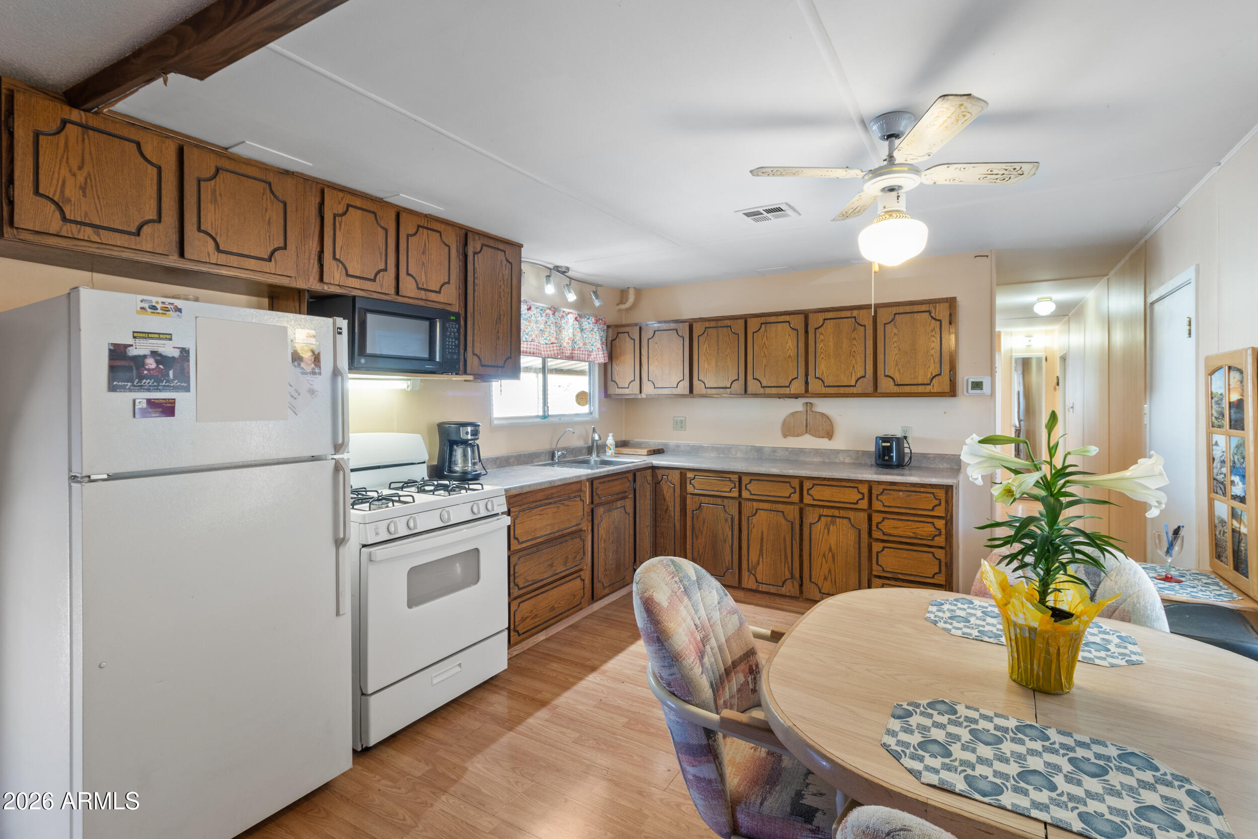 701 South Dobson Road, Unit 343 Mesa, AZ 85202 - Photo 9 of 70 a kitchen with stainless steel appliances granite countertop a refrigerator a stove a sink dishwasher and white cabinets with wooden floor