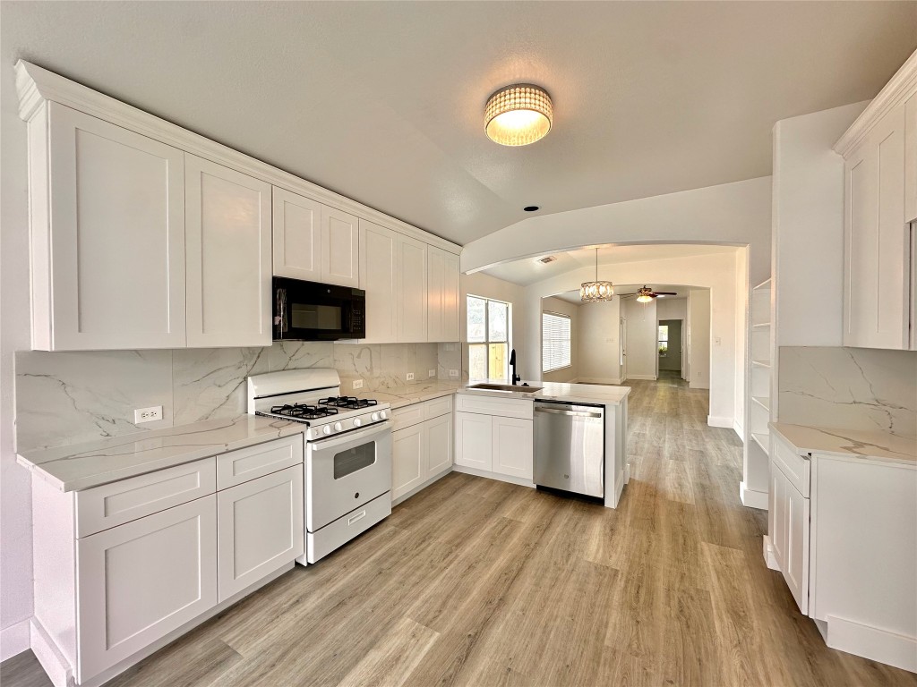 8202 Radial Court Rosharon, TX 77583 - Photo 12 of 27 a kitchen with a sink wooden floor and stainless steel appliances