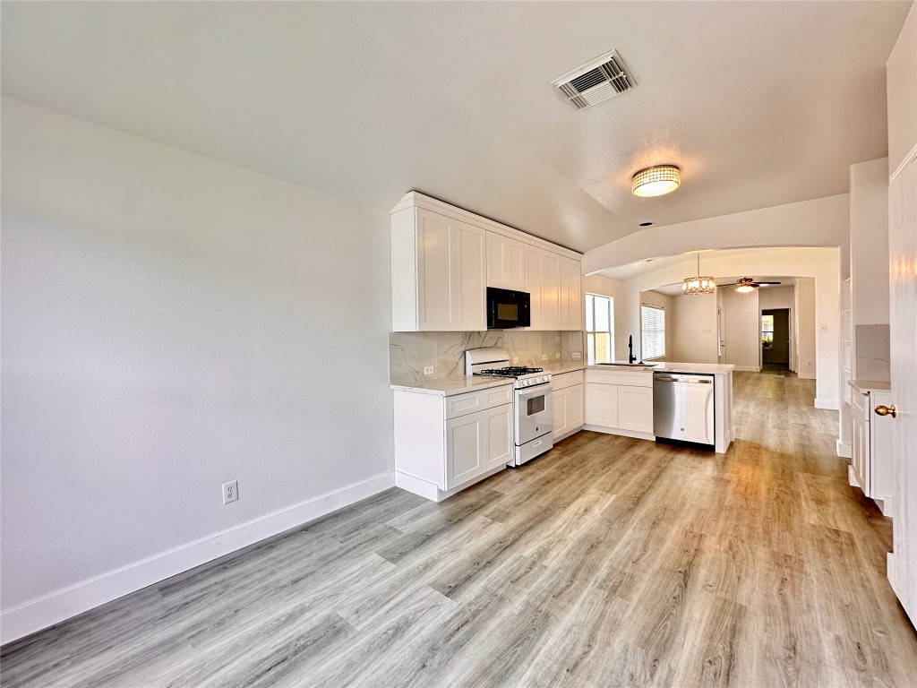 8202 Radial Court Rosharon, TX 77583 - Photo 14 of 27 a kitchen with stainless steel appliances wooden floor and white cabinets